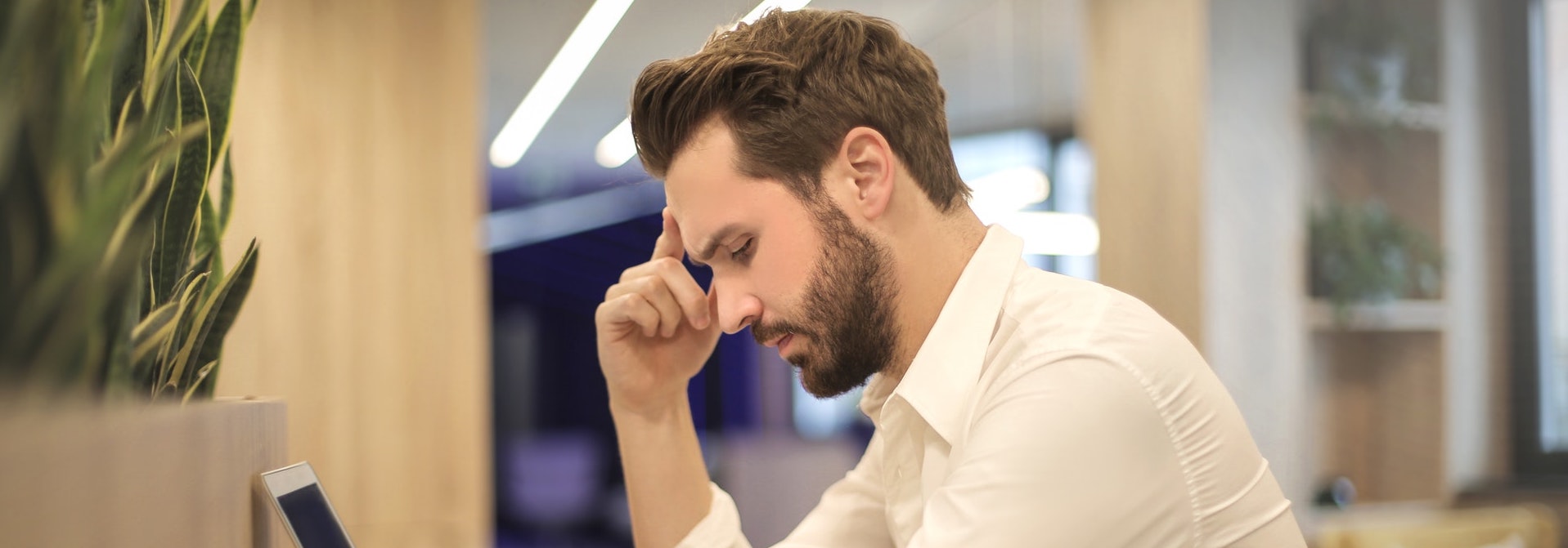 Homme reflechissant sur son ordinateur au bureau