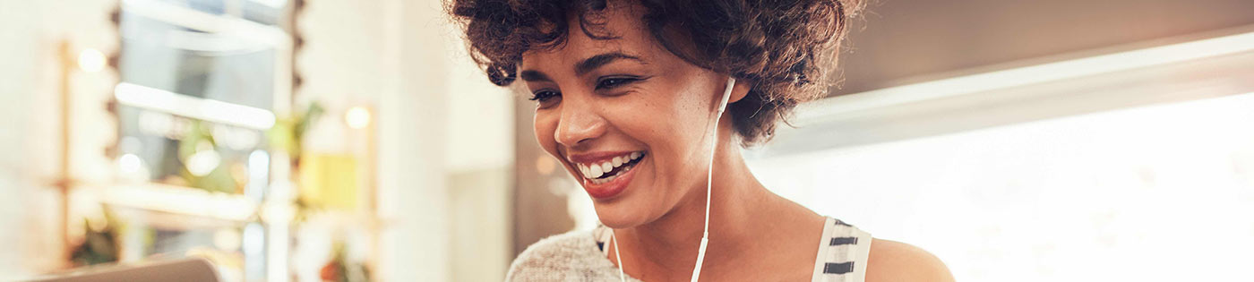 Femme souriante devant l'écran de son ordinateur